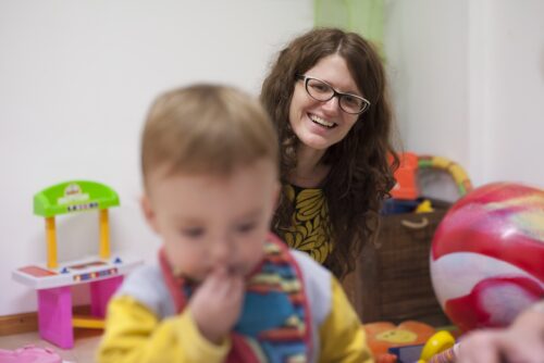 mother-smiles-her-child-as-he-plays-early-stimulation-session-min
