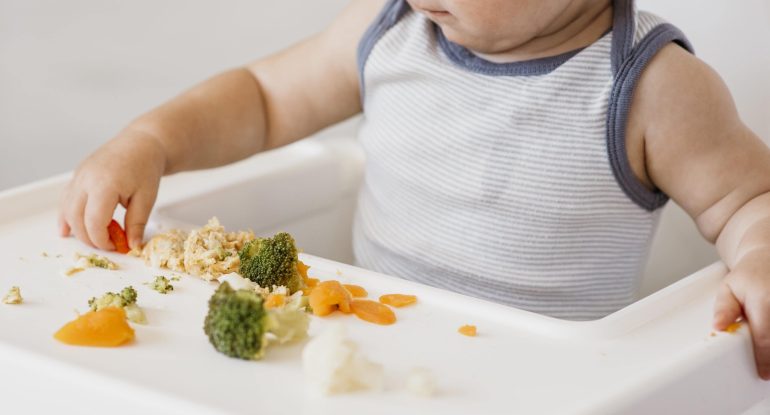 cute-baby-boy-highchair-choosing-what-eat-min cute-baby-boy-highchair-choosing-what-eat-min