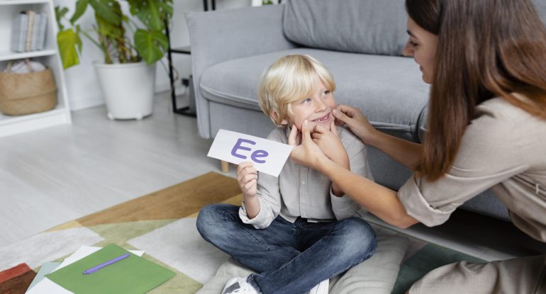 young-woman-doing-speech-therapy-with-little-blonde-boy-min young-woman-doing-speech-therapy-with-little-blonde-boy-min